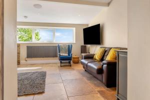 a living room with a couch and a television at Luxury Escape with Cinema, Pool Table & Darts in Leeds +30 photos