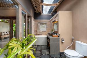a bathroom with a tub and a toilet and a sink at ArtVilla Sidemen River in Sidemen +48 photos