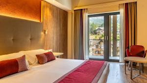 a bedroom with a bed and a large window at TH Courmayeur in Courmayeur +50 photos