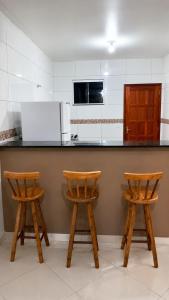 a kitchen with two wooden stools at a counter at Unamar Beach in Cabo Frio