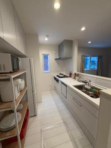a white kitchen with a sink and a microwave at 雪宿snow iin in Kutchan