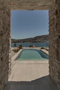 an external view of a swimming pool through a stone wall at Eunoia Suites in Krotiri