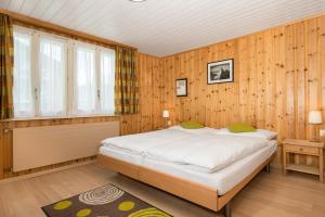 a bedroom with a large bed in a wooden wall at Hotel Alpina in Zermatt