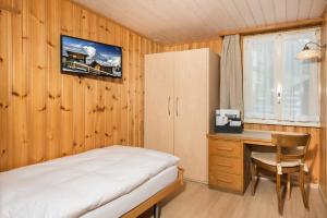 a bedroom with a desk and a bed and a desk and chair at Hotel Alpina in Zermatt