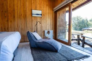 a bedroom with a bed and a large window at Peuma Lodge Patagonia in Futaleufú
