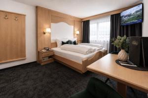 a hotel room with a bed and a tv at Garni Rustica in Sölden