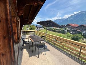 a table and chairs with an umbrella on a balcony at Hotel Milan - Self Check-In in Ringgenberg