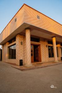 a large brick building with pillars in a parking lot at Skyblue GuestHouse in Lubumbashi +1 photo