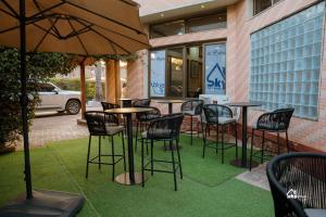 a group of tables and chairs with an umbrella at Skyblue GuestHouse in Lubumbashi
