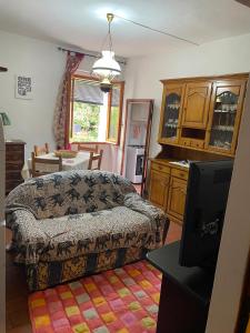 a living room with a couch and a kitchen at La chiesina delle conce in Sarteano