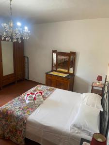 a bedroom with a bed with a dresser and a mirror at La chiesina delle conce in Sarteano