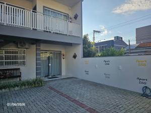 a white house with a balcony and a patio at Apart ZSS in Penha