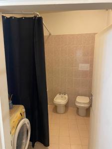 a bathroom with a toilet and a black shower curtain at La chiesina delle conce in Sarteano +4 photos