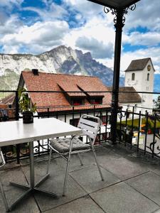 a table and a chair on a balcony with a mountain at Garni Sternen in Obstalden