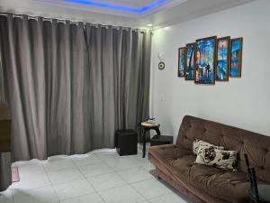 a living room with a brown couch in front of a window at Apart ZSS in Penha