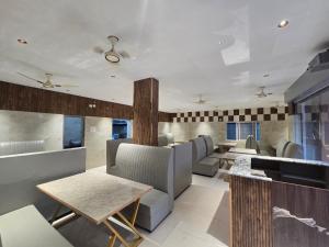 a dining room with chairs and tables and windows at Hotel Royal Akkamahadevi in Sundi Penta +5 photos