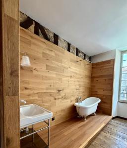 a bathroom with wooden walls and a tub and a sink at Le dardenne-Hôtel particulier historique in Villefranche-de-Rouergue