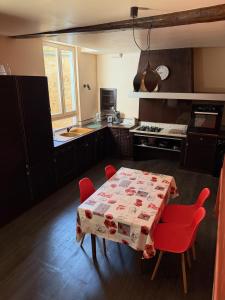 a kitchen with a table with red chairs and a kitchen with a stove at Le dardenne-Hôtel particulier historique in Villefranche-de-Rouergue +10 photos