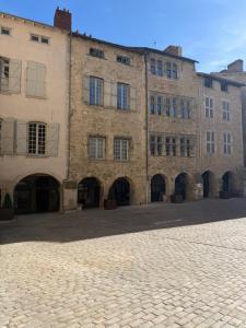 a large brick building on a cobblestone street at Le dardenne-Hôtel particulier historique in Villefranche-de-Rouergue