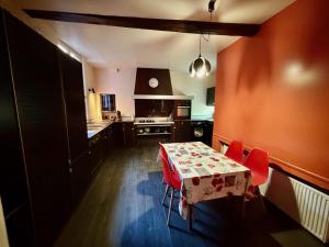 a kitchen with a table and red chairs in it at Le dardenne-Hôtel particulier historique in Villefranche-de-Rouergue