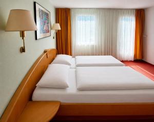 a hotel room with two beds and a window at Hotel Kull von Schmidsfelden in Bad Herrenalb