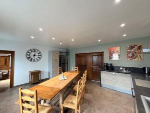 a kitchen and dining room with a wooden table and chairs at Gite Maison Saint-Martin in La Groise