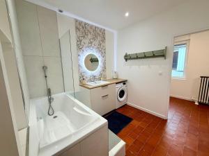 a bathroom with a tub and a washing machine at Gite Maison Saint-Martin in La Groise +35 photos