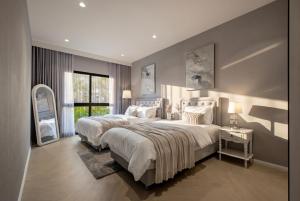 a large bedroom with two beds and a mirror at Luxury 2 bedroom pool access apartment in Bang Tao Beach +125 photos