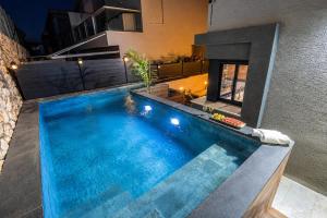 a swimming pool in the backyard of a house at אחוזת אבישג - וילה יוקרתית עם בריכה מחוממת וממ"ד למשפחות in Shelomi +30 photos
