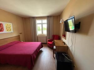 a hotel room with two beds and a flat screen tv at Dunas de Oyambre in Comillas