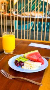 a plate of fruit and a glass of orange juice at Praia Mole Hotel in Florianópolis