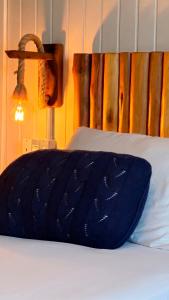 a bed with a blue pillow on top of it at Praia Mole Hotel in Florianópolis