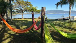 two hammocks in a park next to the water at Praia Mole Hotel in Florianópolis +59 photos