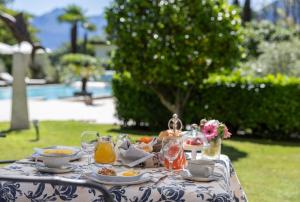 a blue and white table with food and drinks on it at Boutique-Hotel REMORINO, a Lago Maggiore GARDEN RESORT in Locarno +22 photos