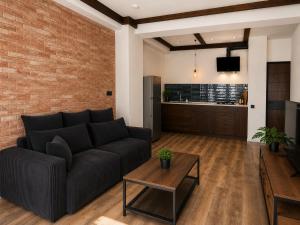 a living room with a couch and a brick wall at Matilda Signature Apartments in Telavi