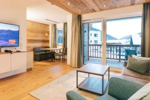 a living room with a couch and a tv at Venediger Lodge in Neukirchen am Großvenediger