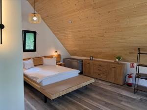 a bedroom with a bed and a wooden ceiling at Kolibe Doftana in Trăisteni