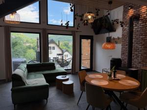 a living room with a green couch and a table at Kolibe Doftana in Trăisteni