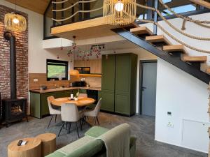 an open kitchen and dining room with a table and a staircase at Kolibe Doftana in Trăisteni