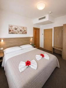 a bedroom with a large bed with red and white bows at HOTEL TRIESTE in Riccione