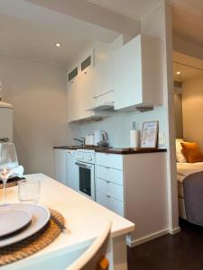 a small kitchen with white cabinets and a bed at KODA Walk Everywhere in Rovaniemi