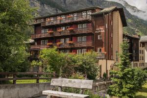 a building with a bench in front of it at Hotel Alpina in Zermatt