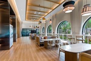 a restaurant with tables and chairs and windows at Luxury 2 bedroom pool access apartment in Bang Tao Beach