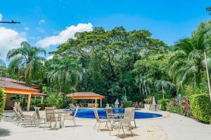 a patio with chairs and a swimming pool at Casa Villa Ensueño in Jacó