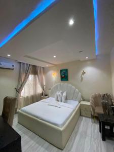 a bedroom with a large white bed in a room at S&B Hotel in Agege