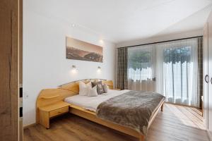 a bedroom with a bed and a large window at Ferienhaus Anton in Gerlosberg