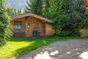 a log cabin with a chair in the yard at Ferienhaus Anton in Gerlosberg