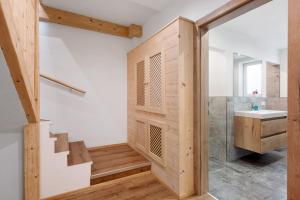 a bathroom with a wooden wall and a sink at Ferienhaus Anton in Gerlosberg +30 photos