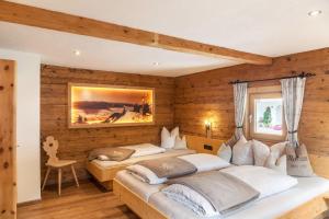 two beds in a room with wooden walls at Neuhaus Alm in Gerlosberg