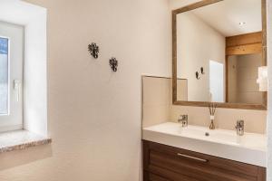 a bathroom with a sink and a mirror at Neuhaus Alm in Gerlosberg +24 photos